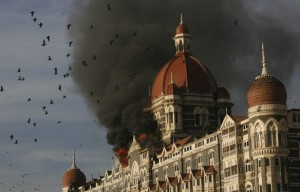 Pigeons fly as the Taj Hotel continues to burn in Mumbai, India, Thursday, Nov. 27, 2008. Teams of heavily armed gunmen stormed luxury hotels, a popular restaurant, hospitals and a crowded train station in coordinated attacks across India's financial capital Wednesday night, killing at least 82 people and taking Westerners hostage, police said. A previously unknown group, apparently Muslim militants, took responsibility for the attacks. (AP Photo/Gautam Singh)