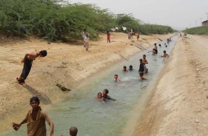 HUB, PAKISTAN, JUN 15: Children enjoying in Lasbella Canal to beat the heat on a hot day of  summer season in Hub on Saturday, June 15, 2013. (Arshad Baloch/PPI Images).