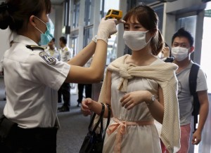 A flight passenger from Busan, South Korea, receives a temperature check upon her arrival at Hong Kong Airport in Hong Kong, China June 5, 2015. South Korean authorities squabbled on Friday over their handling of an outbreak of Middle East Respiratory Syndrome (MERS), as a fourth person died and five new cases were reported.       REUTERS/Bobby Yip