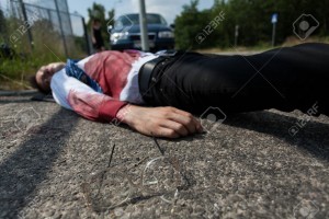 Bleeding man lying on the street after car accident